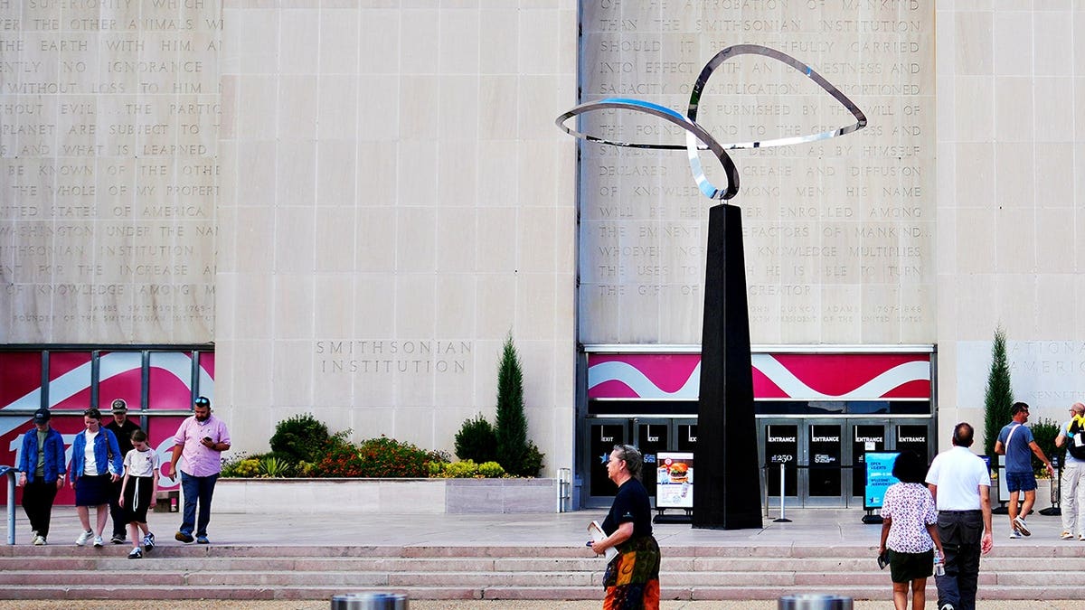 People walk past the Infinity sculpture outside the Smithsonian National Museum of American History on the National Mall.