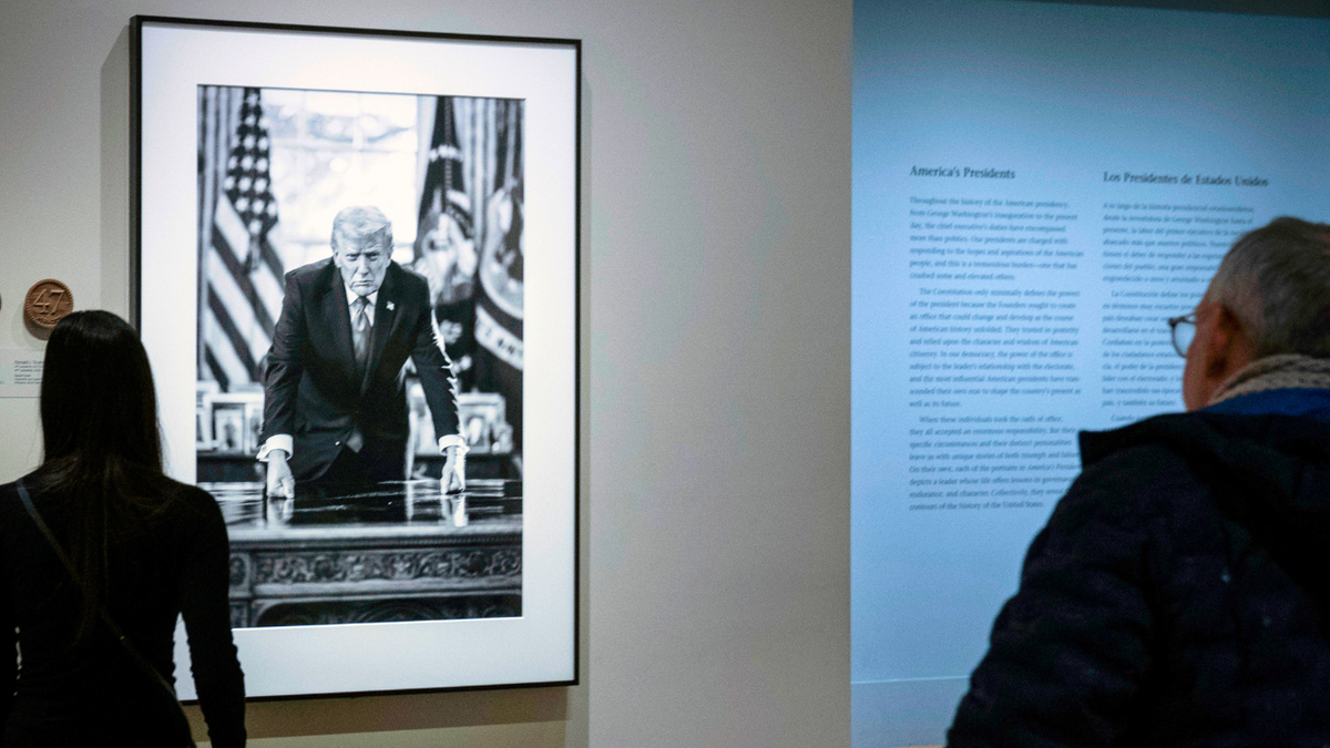 People look at President Donald Trump's portrait at the National Portrait Gallery.